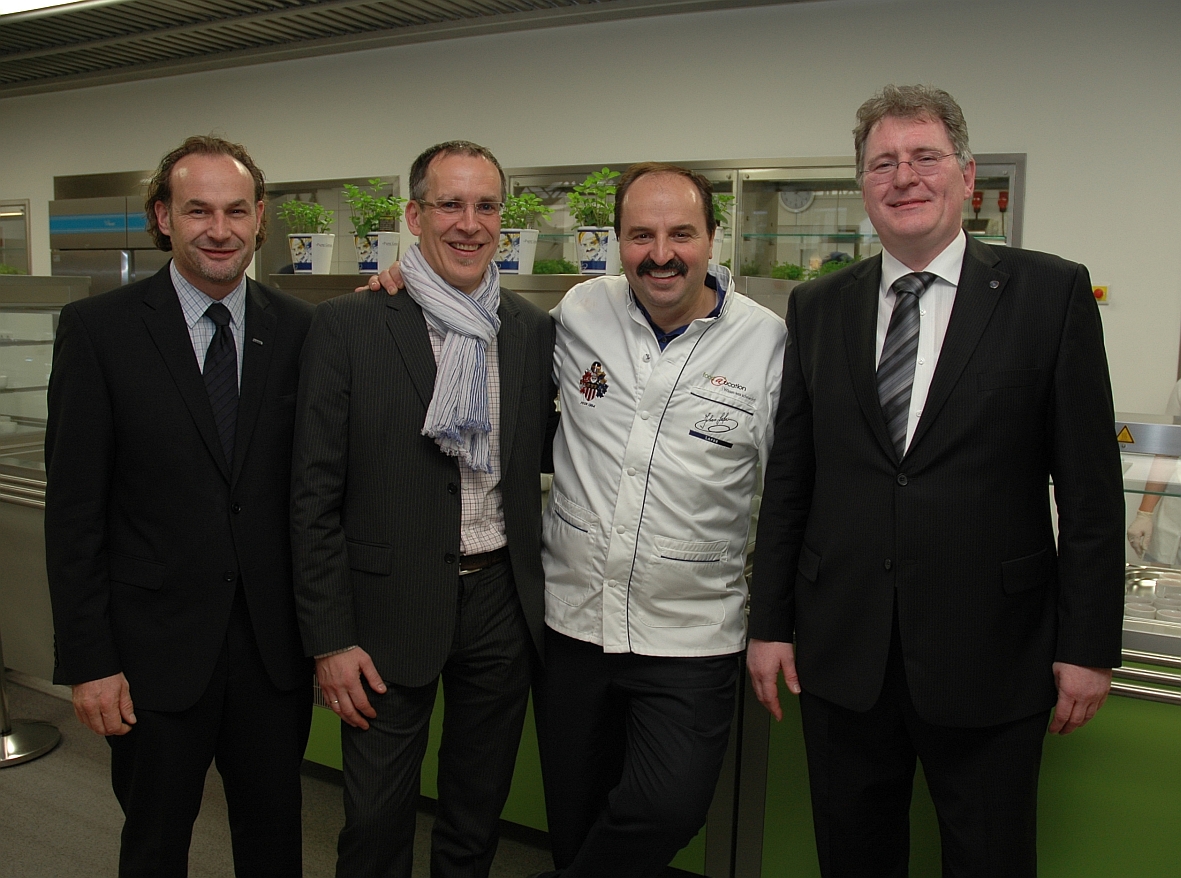 Johann Lafer (2.v.r.) eröffnete am 9. November das Pilotprojekt Foodeducation, bei dem er im Bereich der Küchenausstattung von Fachhändler Thomas Wendling (2.v.l.) unterstützt wurde. Von Lieferantenseite waren dabei Rainer Müller (MKN, r.) und Martin Braun (Blanco CS). Foto: Lang